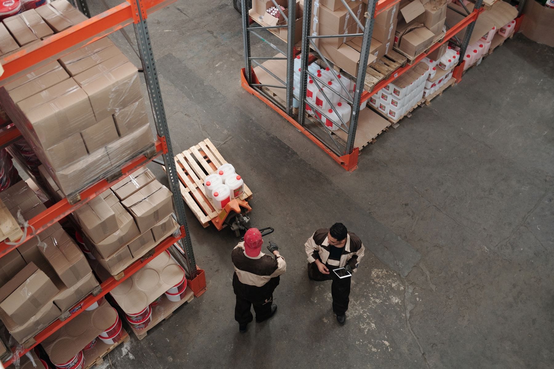 Warehouse employees coordinating work with goods